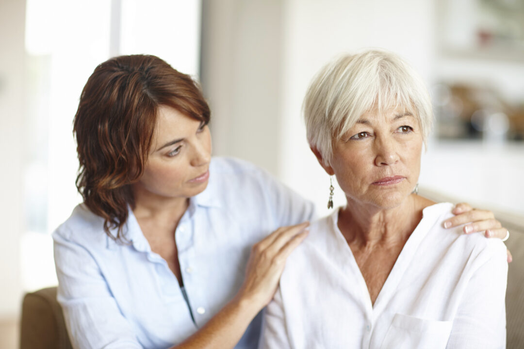 Younger woman offering comfort to an older woman who appears emotionally distressed.