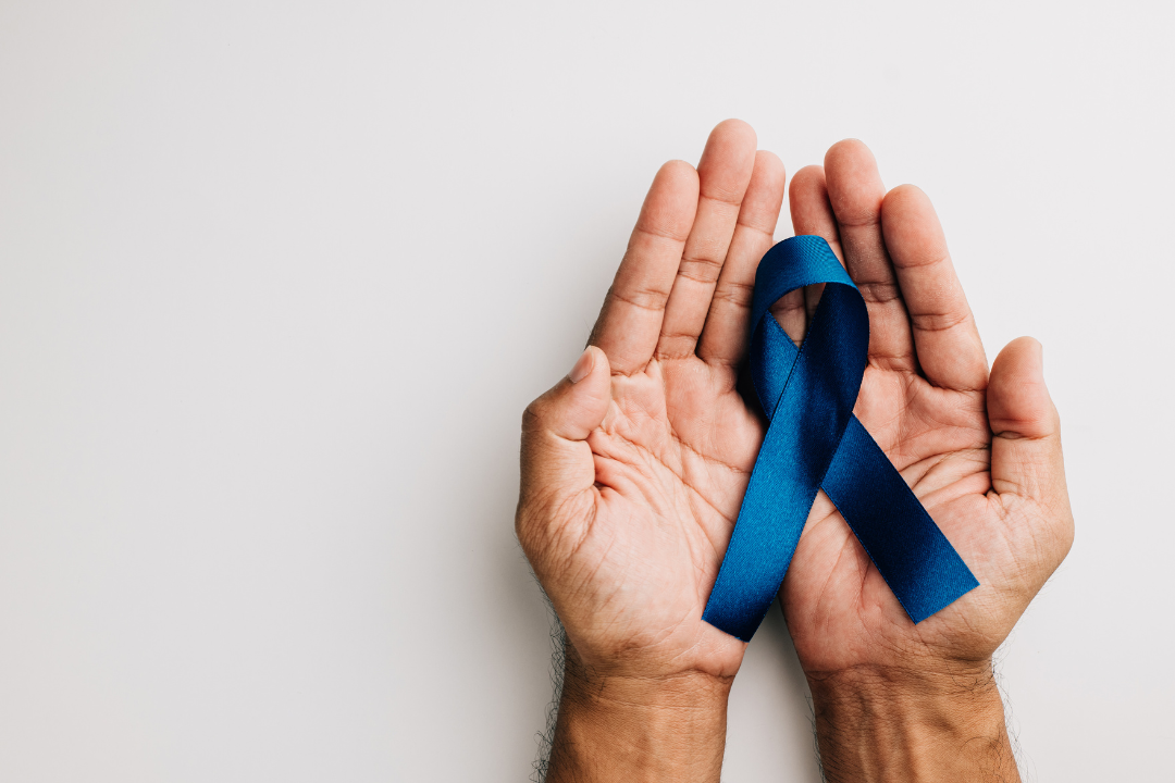 Man holding blue ribbon in support and to create awareness of Men's Mental Health Month